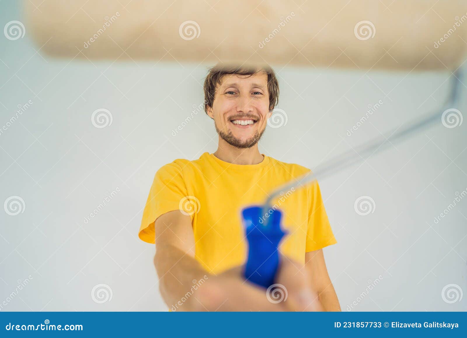 One Male House Painter Worker Painting and Priming Wall with Painting