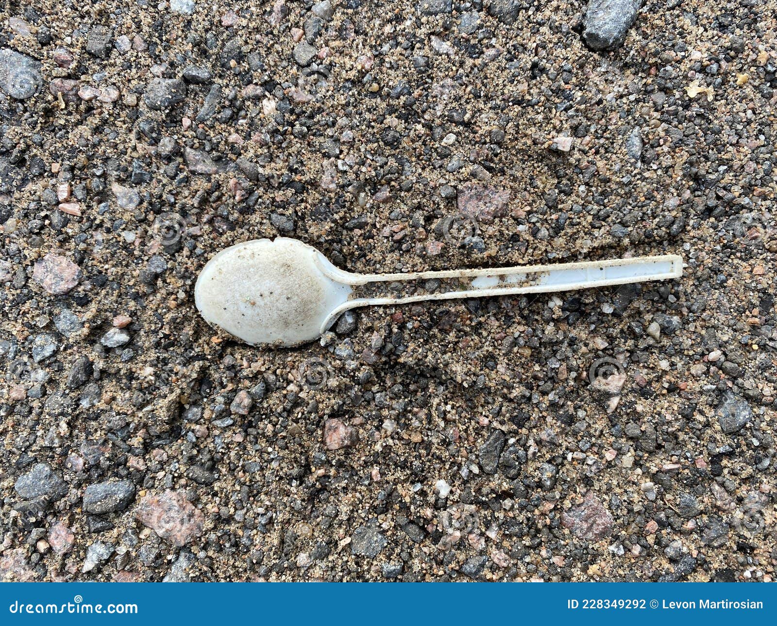 One Plastic Spoon on the Beach. Garbage on the Beach. Stock Photo