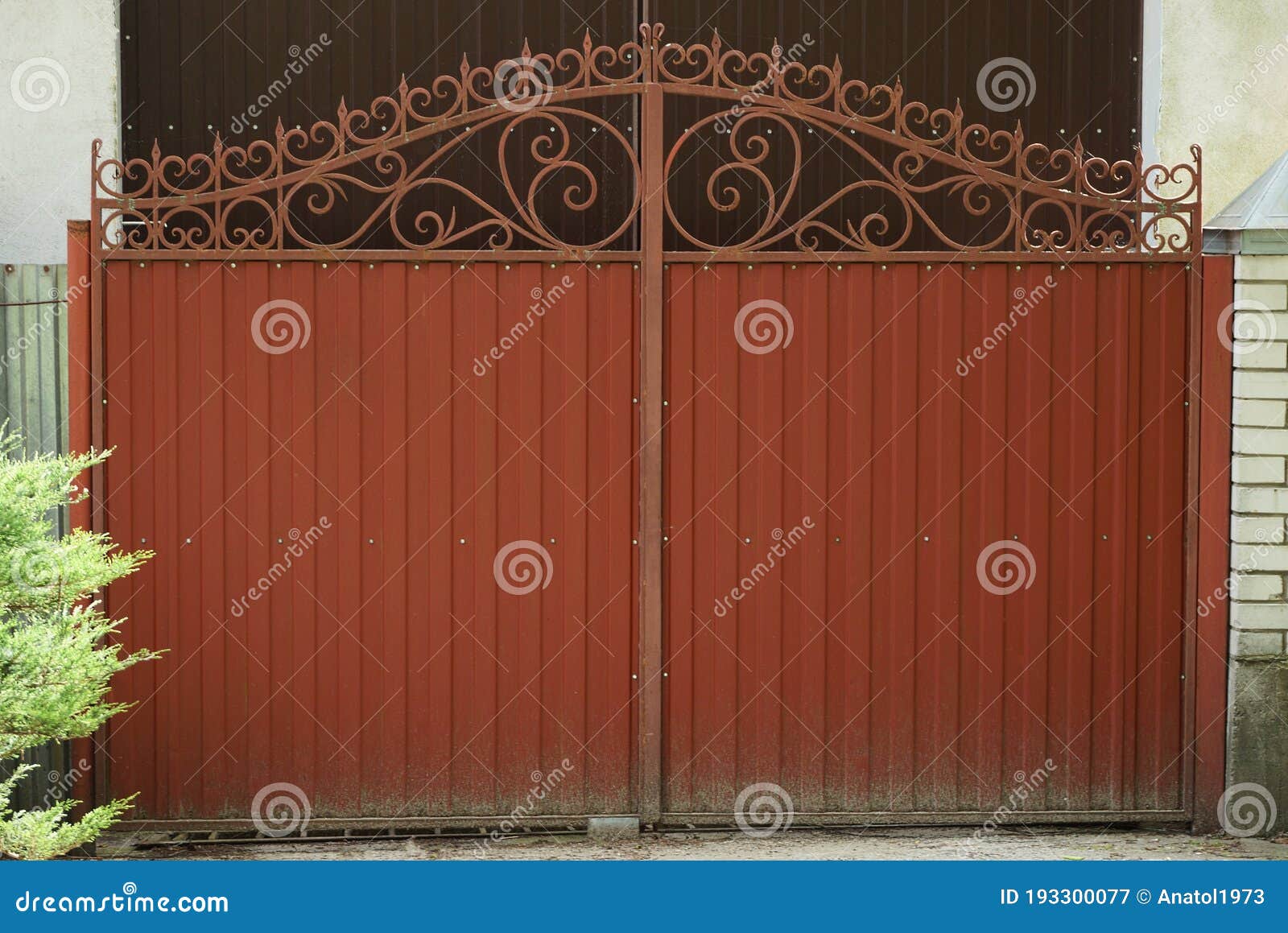 One Red Closed Iron Gate with a Wrought Iron Pattern Stock Image