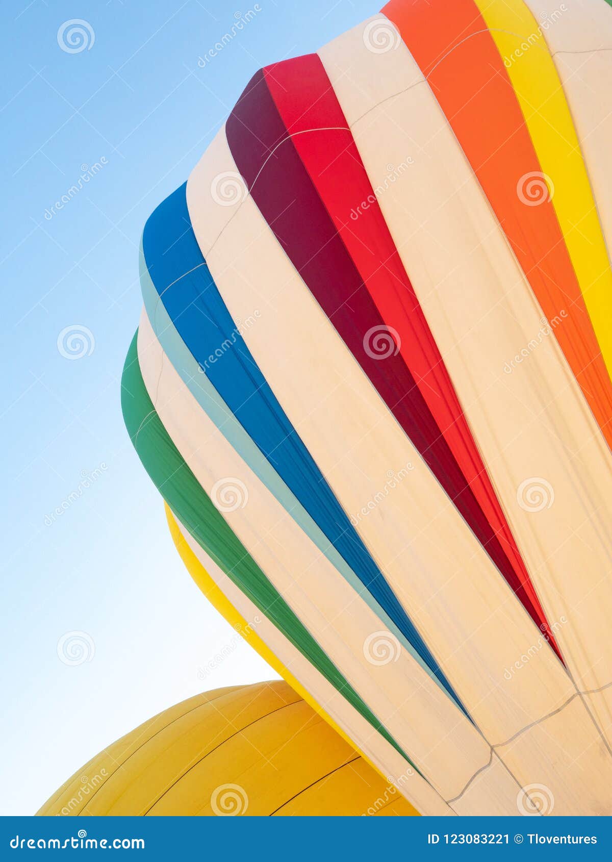 one white hot air balloon with colorful accents and a gold hot a
