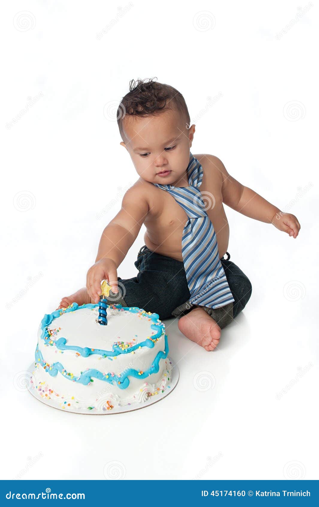 One Year Old Boy with Birthday Cake. A one year old boy grasping the candle on his birthday cake. Shot in the studio on a white background.