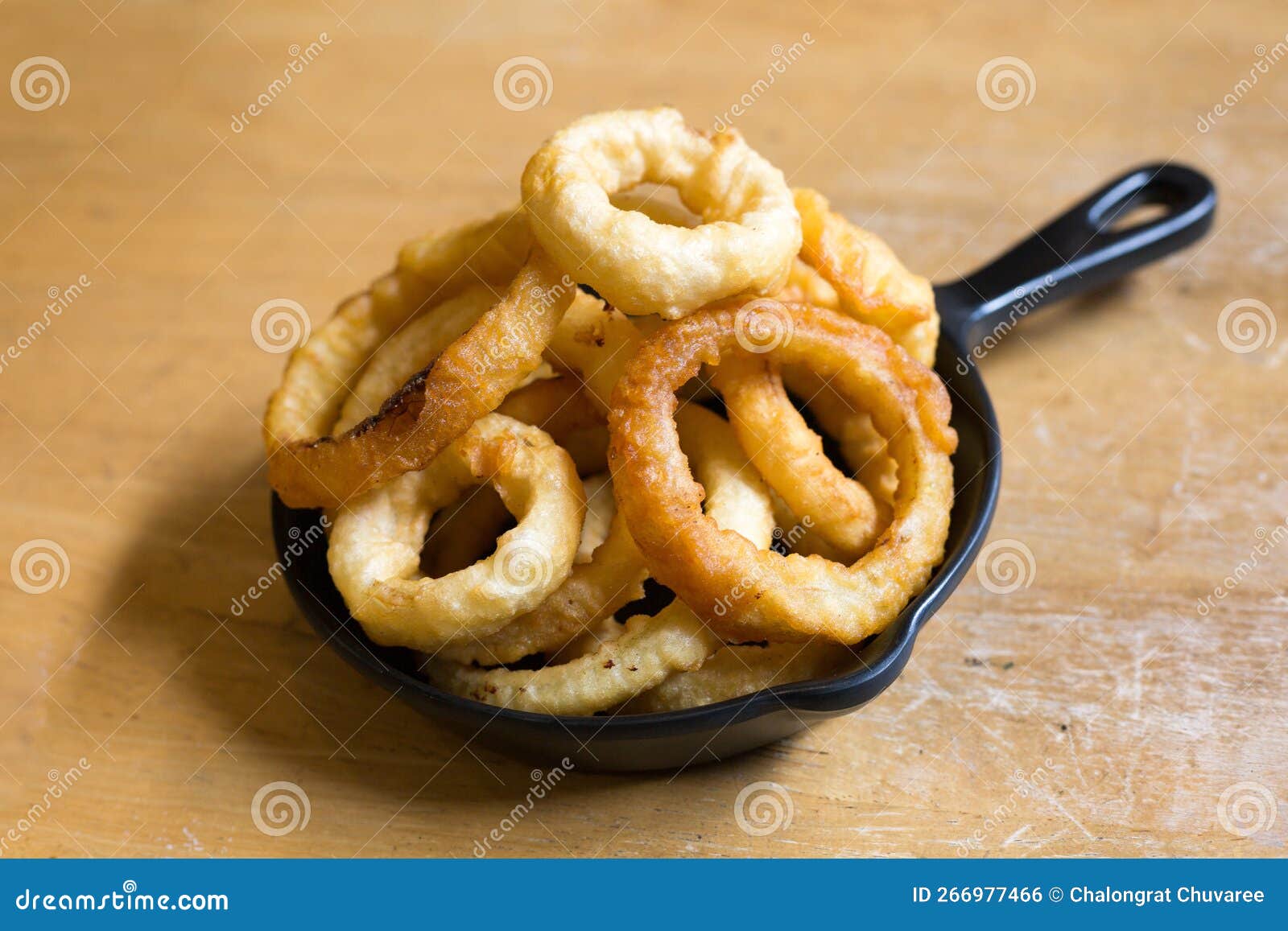 Onion Rings in Black Plate on the Wood Table in Restaurant Stock Photo