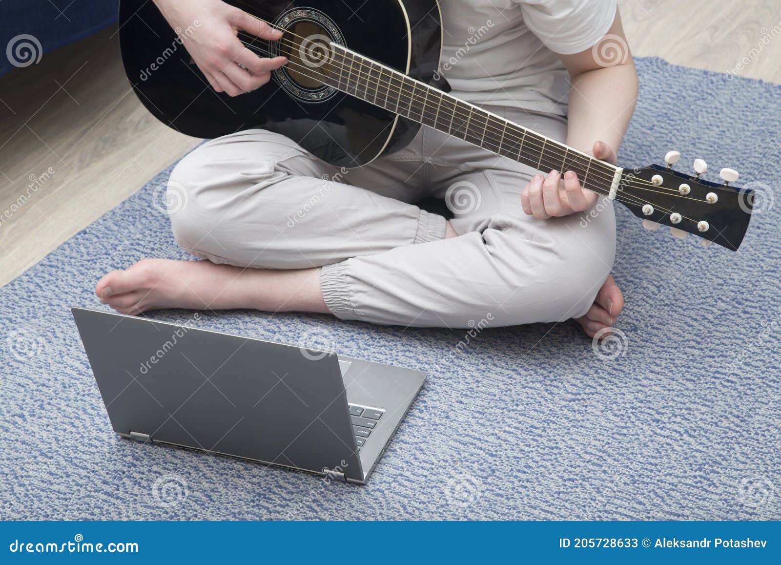 Online Guitar Training.Young Man Learn To Play Guitar through Online