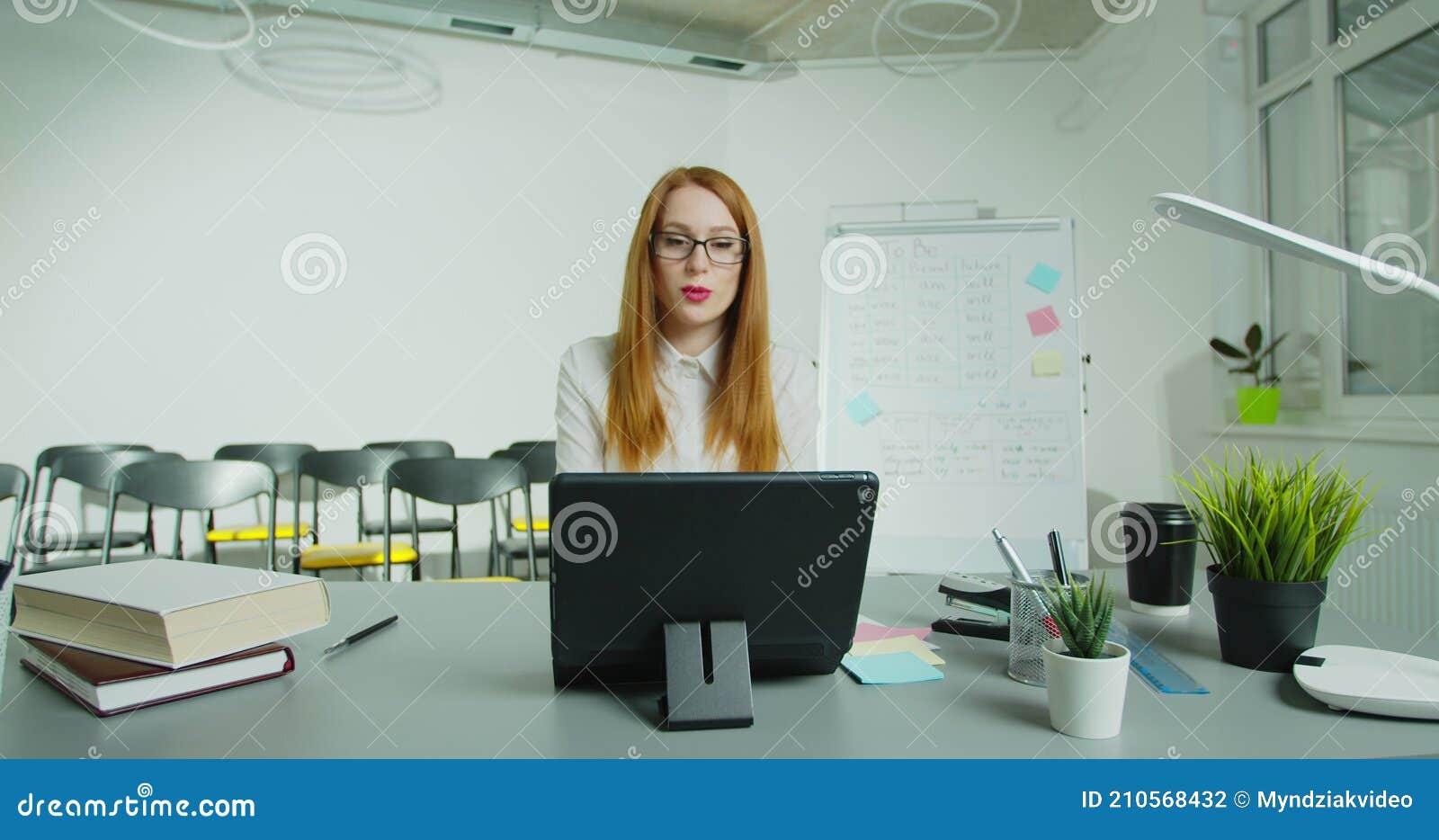 online schooling, e-learning. female teacher is holding online lesson, remotely, using tabletpc. live stream for