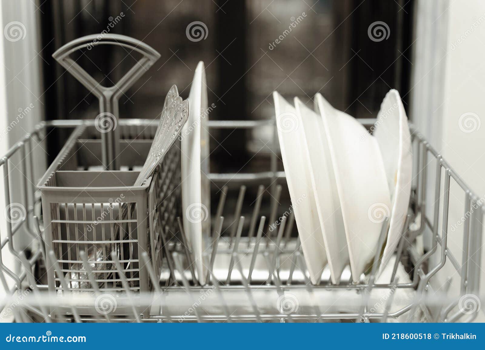 Open Dishwasher with Dirty Dishes. White Cups in the Dishwasher. Stock