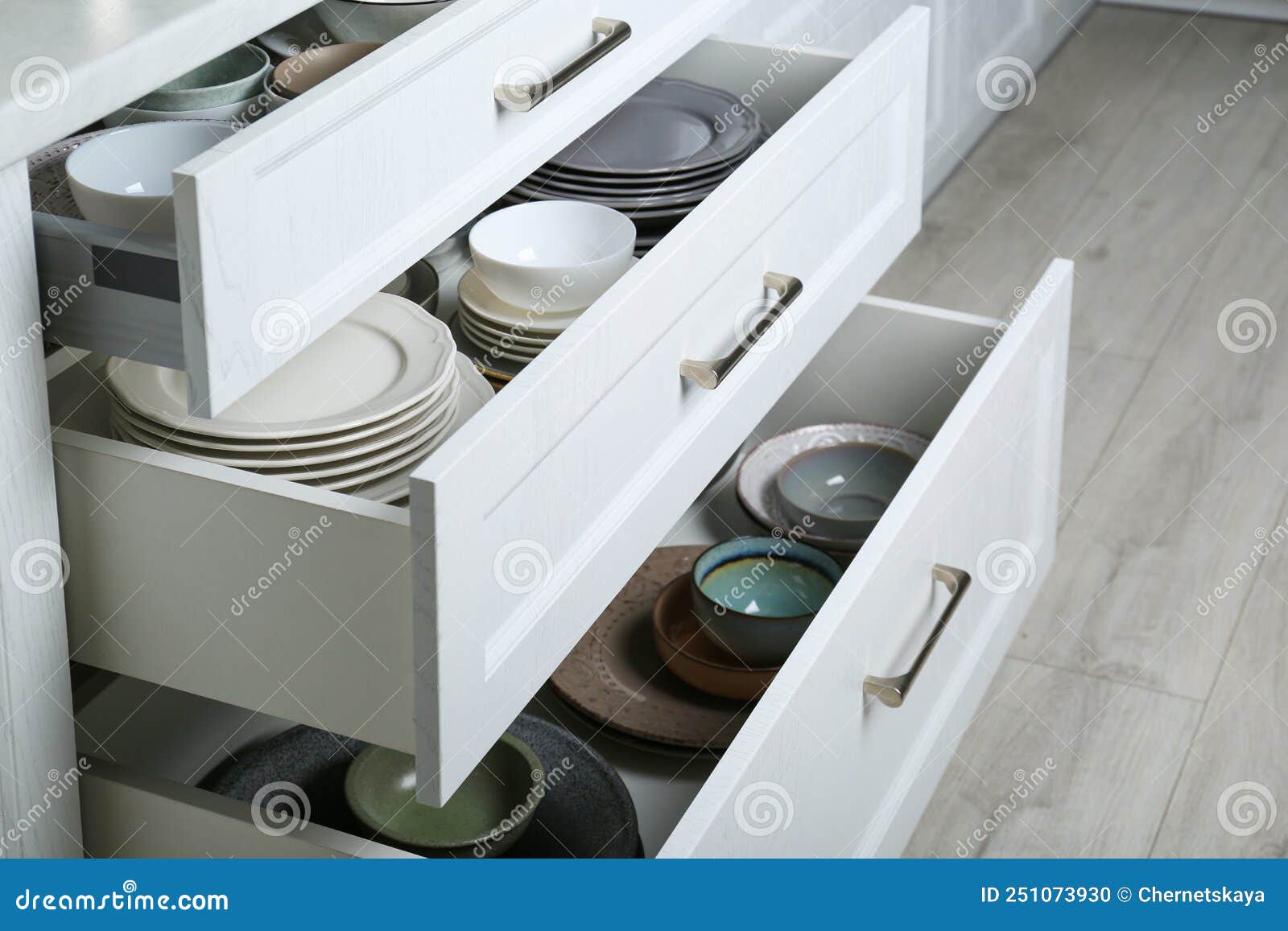 Open Drawers with Different Plates and Bowls in Kitchen Stock Photo
