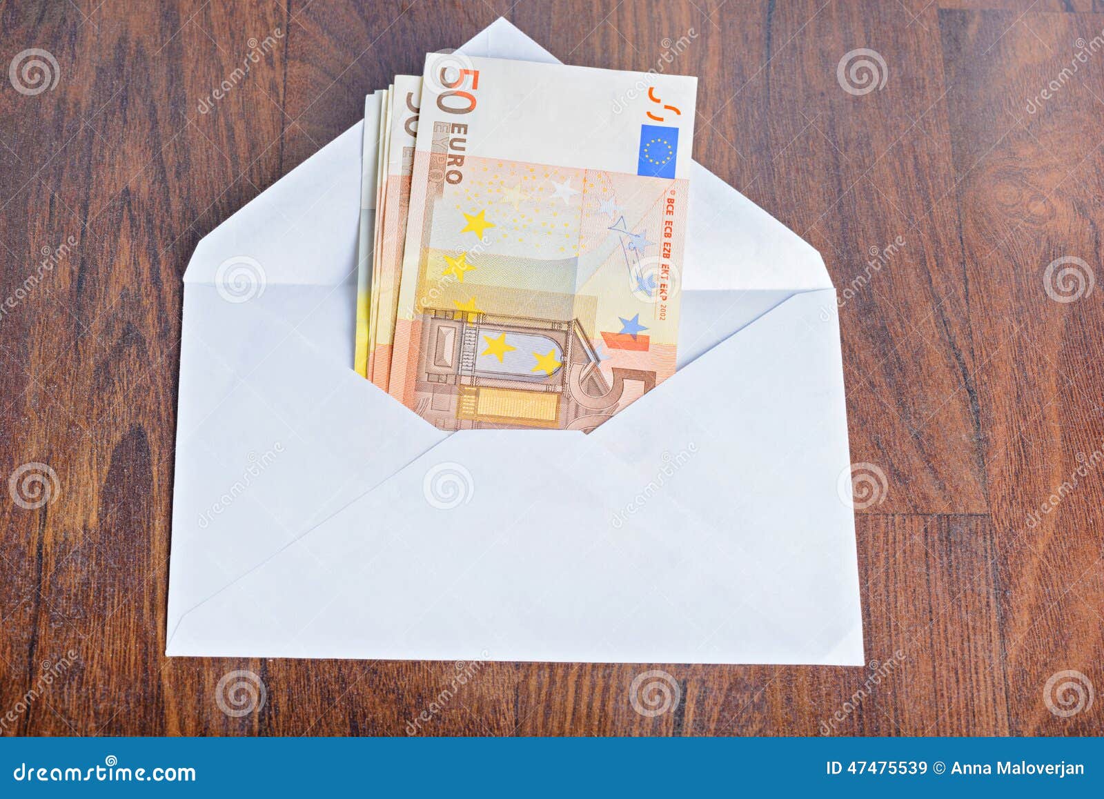 Open envelope with euro banknotes on wooden table