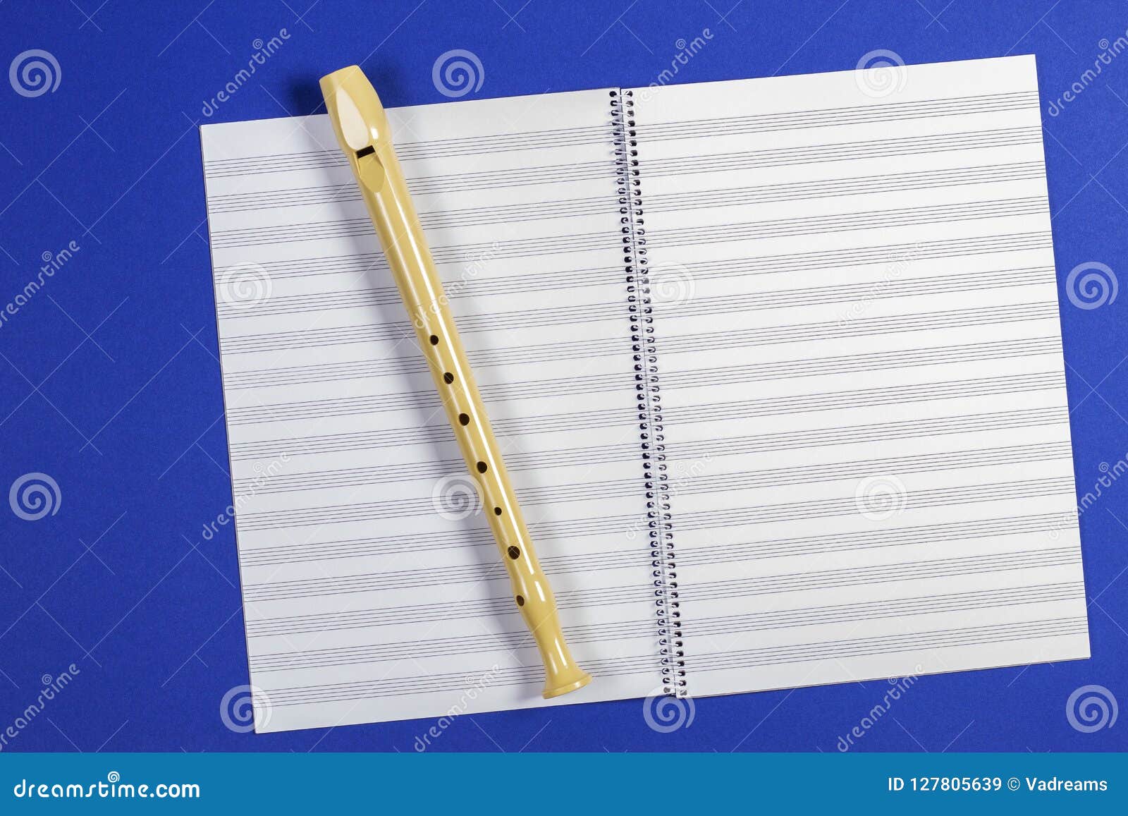 Open Exercise Book with Pentagrams and Musical Instrument Flute on Blue