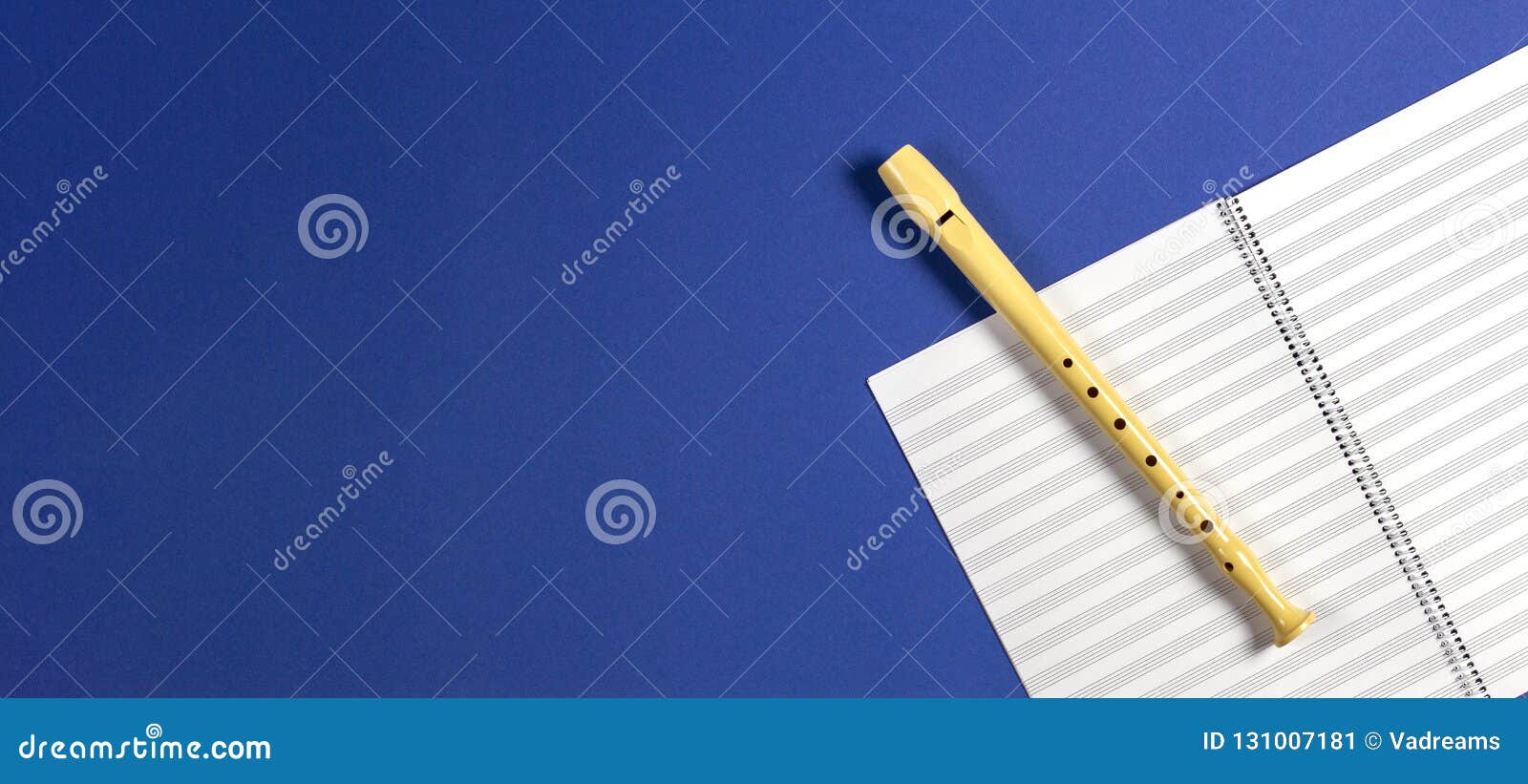 Open Exercise Book with Pentagrams and Musical Instrument Flute on Blue