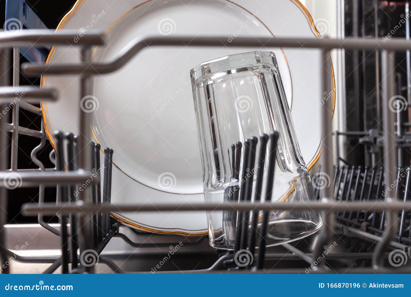 Open Modern Dishwasher with a Clean Washed Glass and White Plate Stock