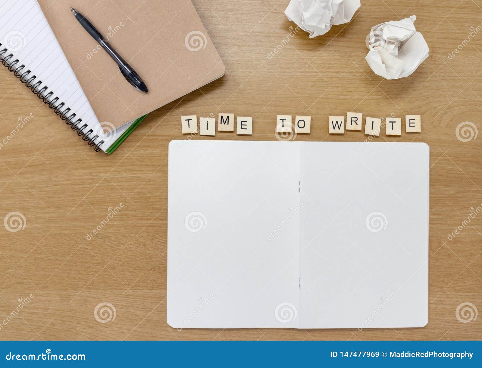 open notebook on a writer or artists desk, with tiles spelling out `time to write`