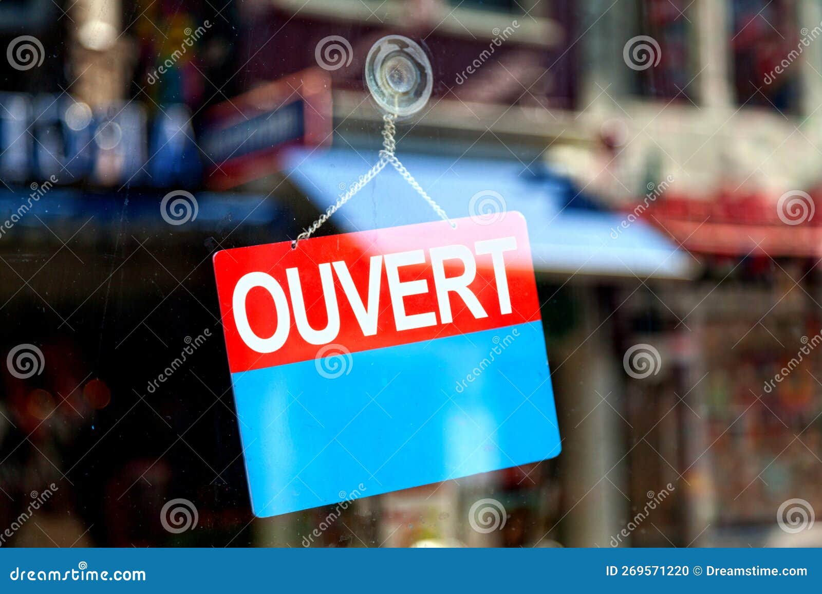 Red and blue sign in the window of a shop saying in French Ouvert, meaning  in English Open Stock Photo - Alamy