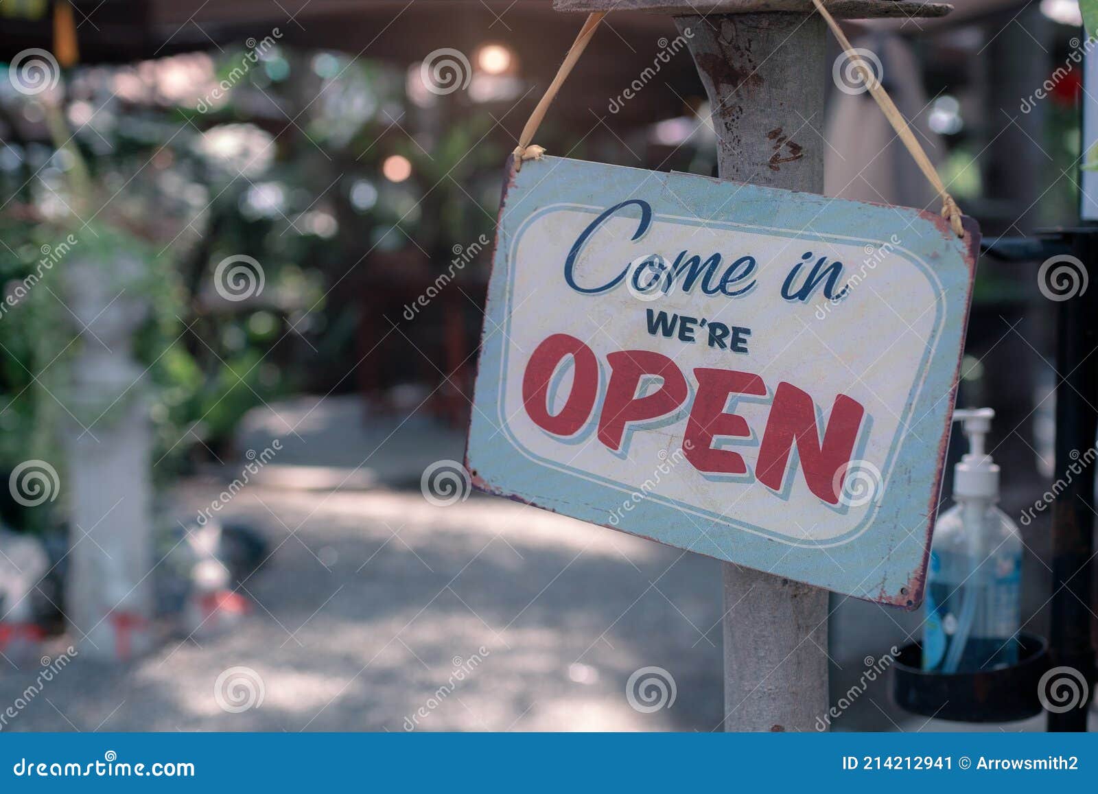 open sign.old rusty metal plate with word come in we`re open with alcohol gel