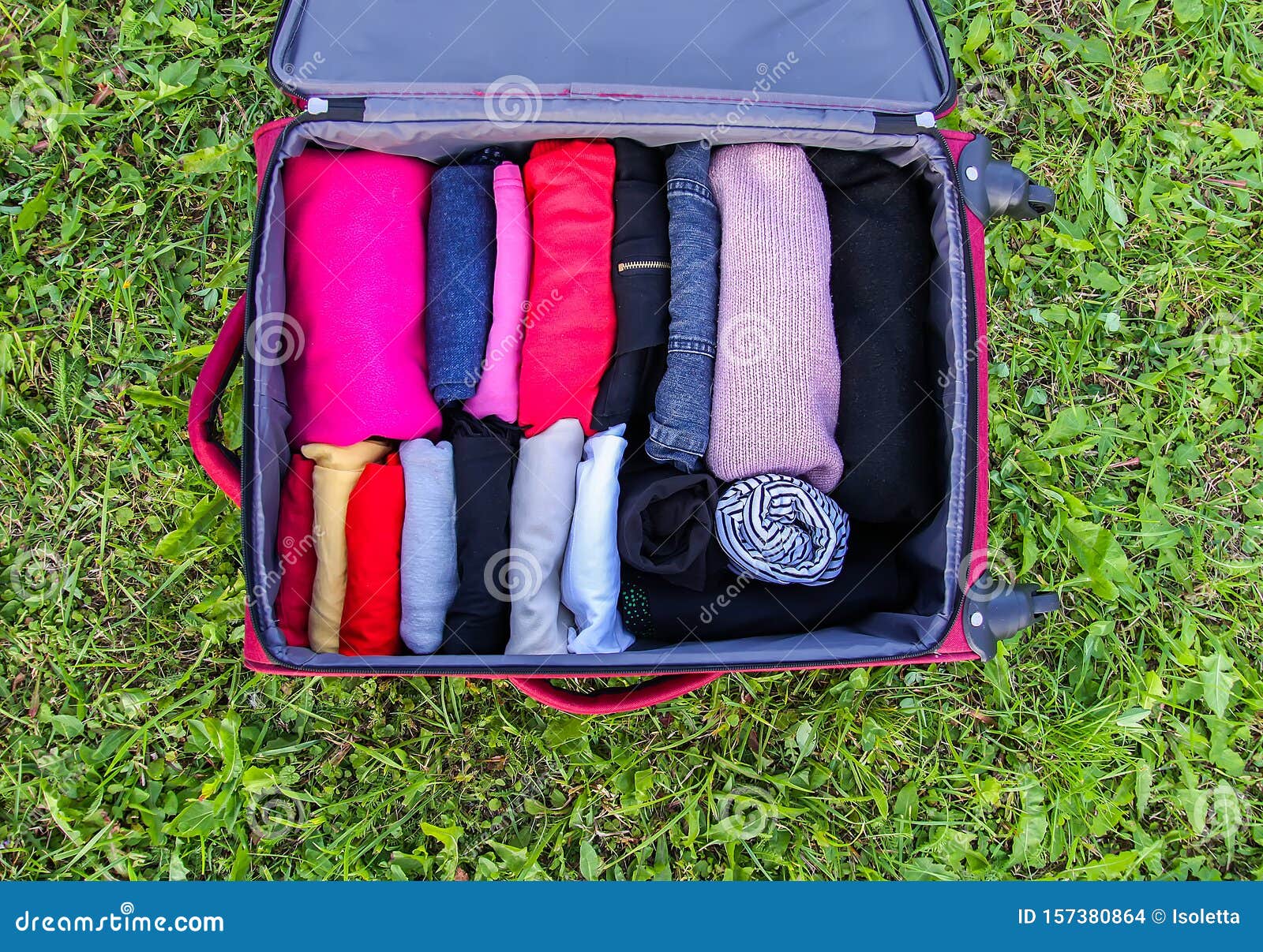 Open Suitcase On The Green Grass With Different Clothes ...