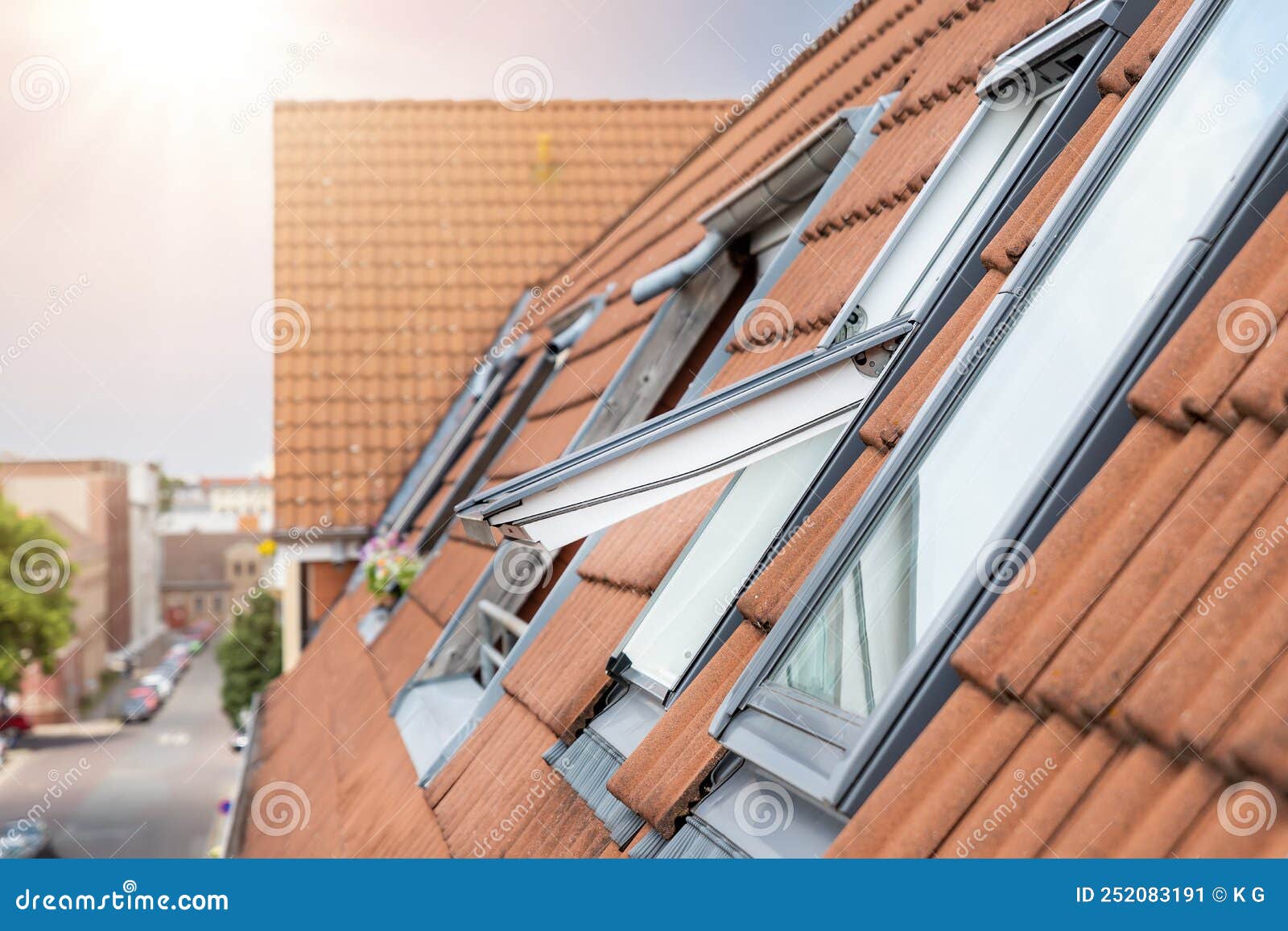 open ventilation waterproof rooftop window exterior against sunny sky light. velux style roof with red brick tiles