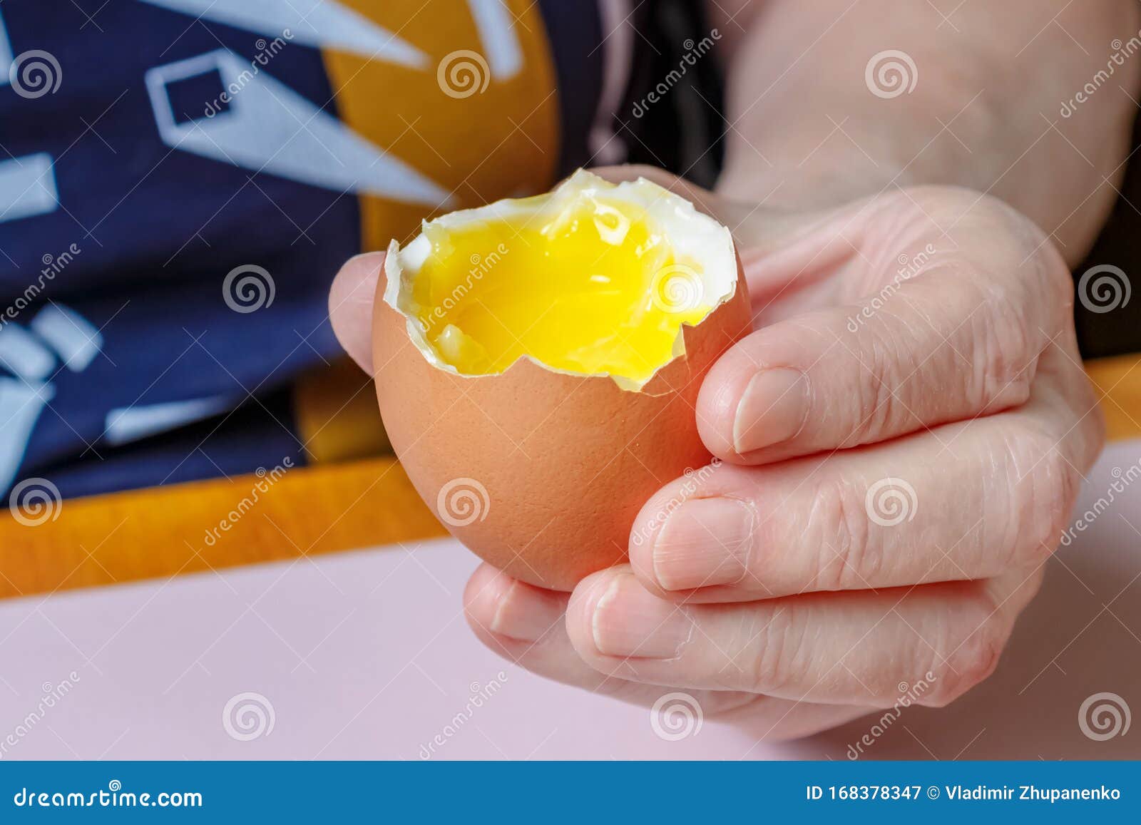 Opened Egg with Liquid Yolk in the Female Hand Closeup Stock Image