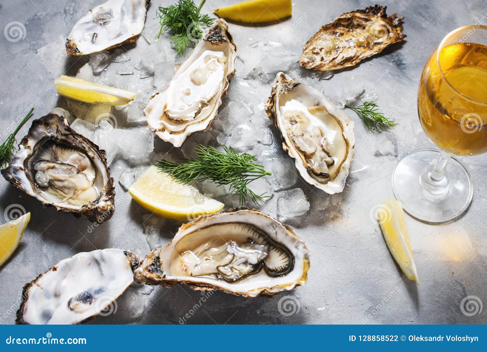 Opened Oysters and Glass of White Wine on Gray Concrete Texture