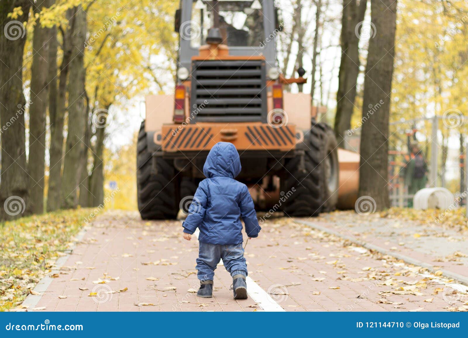 Opinión Trasera El Bebé Enfrente Del Tractor En El Parque Foto de archivo - Imagen de trasera, tractor: 121144710