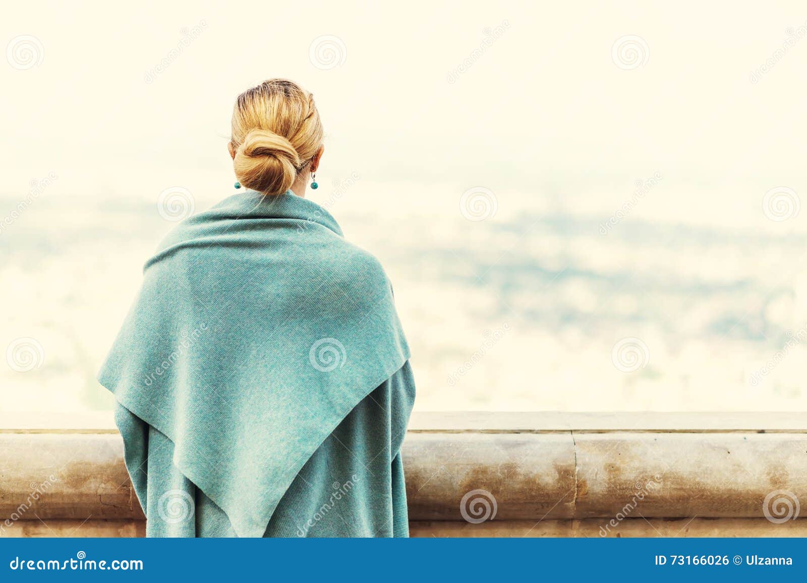 Opinião traseira uma mulher com cabelo louro amarrado. Opinião traseira uma mulher com o cabelo louro amarrado que olha o fundo da natureza durante uma manhã ensolarada agradável Foto com efeito retro do filtro