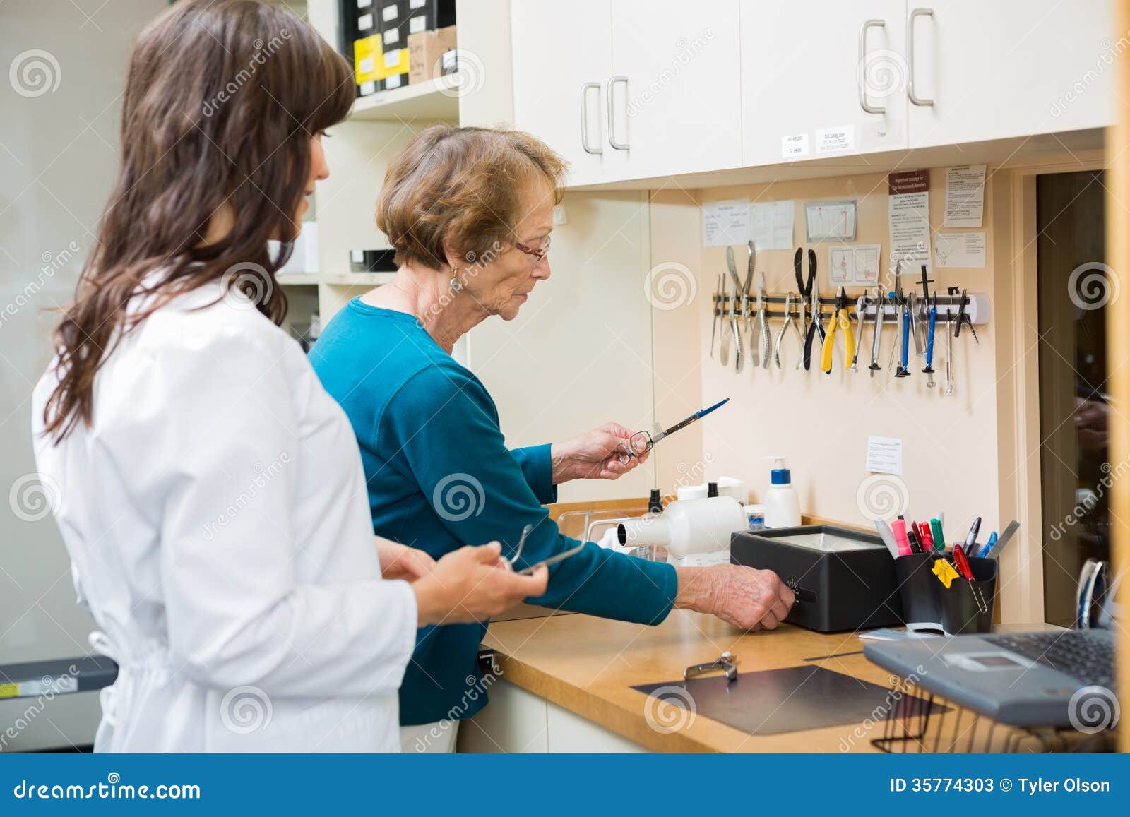 Optician with Apprentice Repairing Glasses in Stock Image Image of