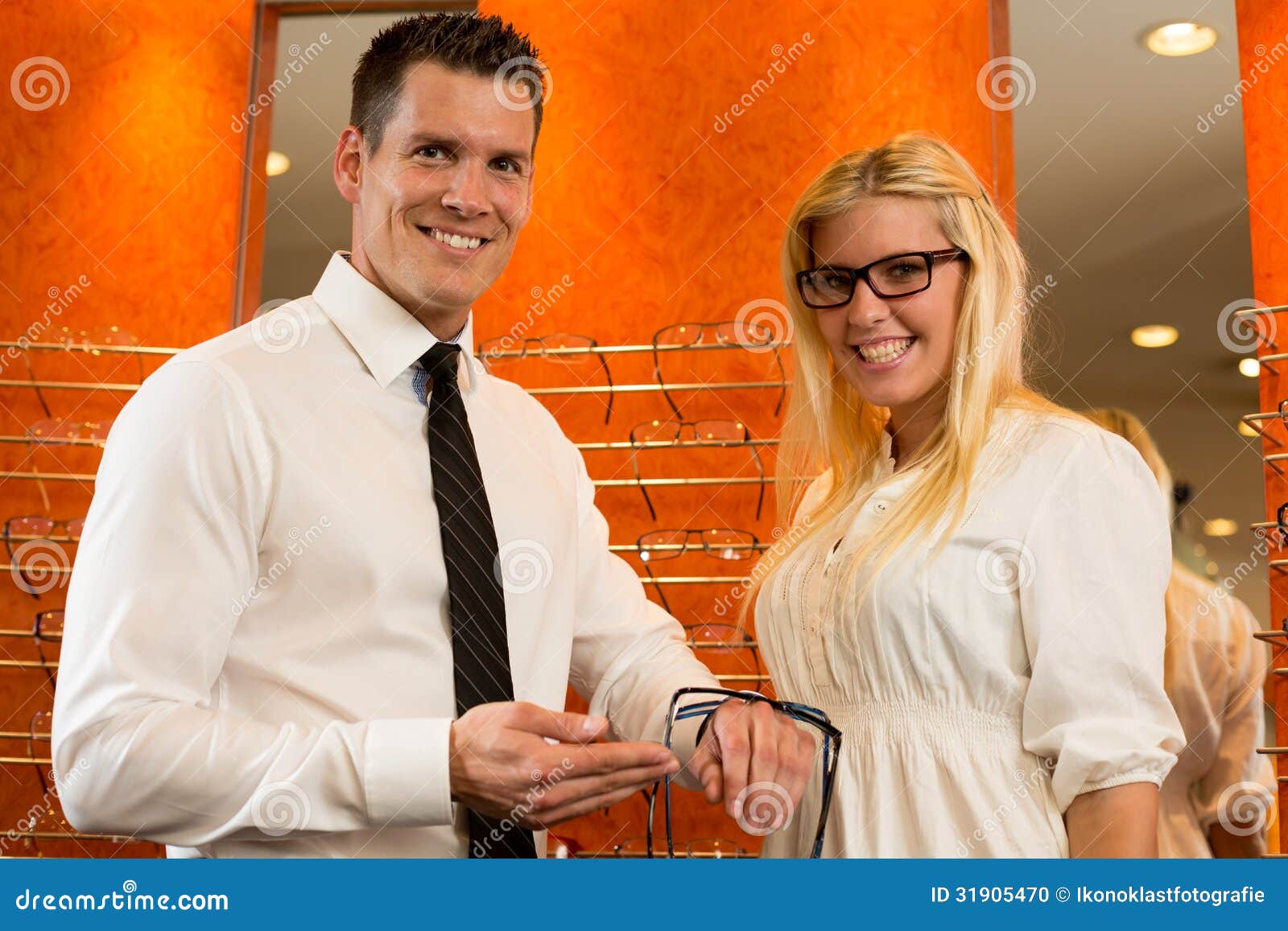 Optician or Optometrist Consulting a Customer about Eyeglasses Stock