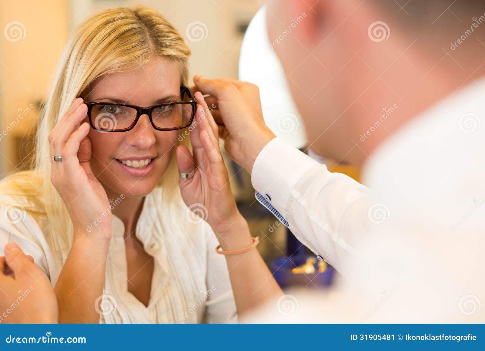 Optician or Optometrist Consulting a Customer about Eyeglasses Stock