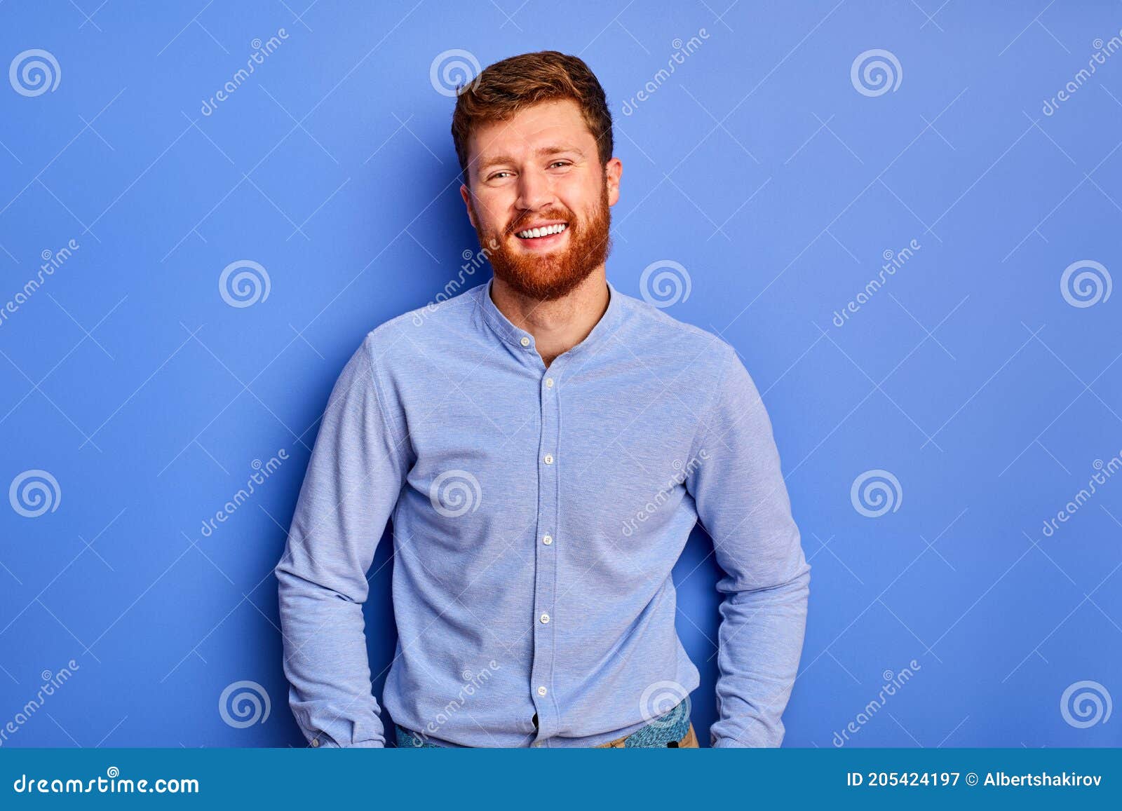 Optimstic Caucasian Guy In Blue Stylish Shirt Smiles At Camera Isolated