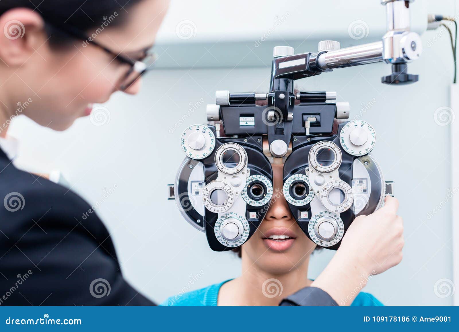 optician and woman at eye examination with phoropter