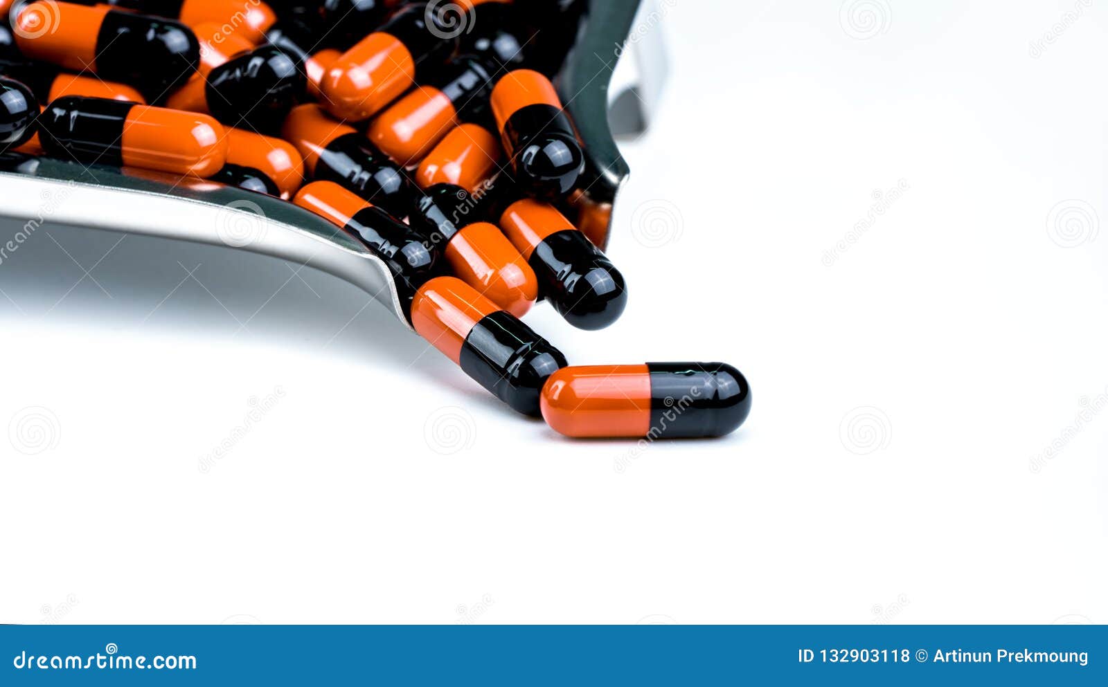orange-black capsule pills on drug tray. antibiotics drug resistance. drug use with reasonable. antimicrobial capsule pills.