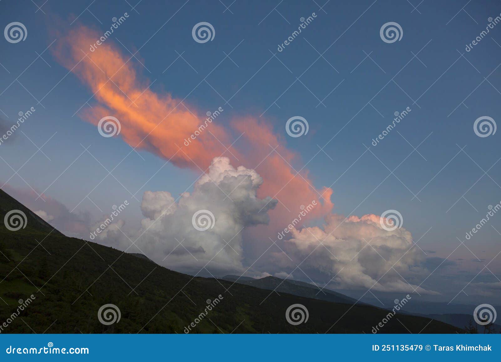 orange cirro-cumulus and cumulus clouds in the evening light at sunset in the mountains