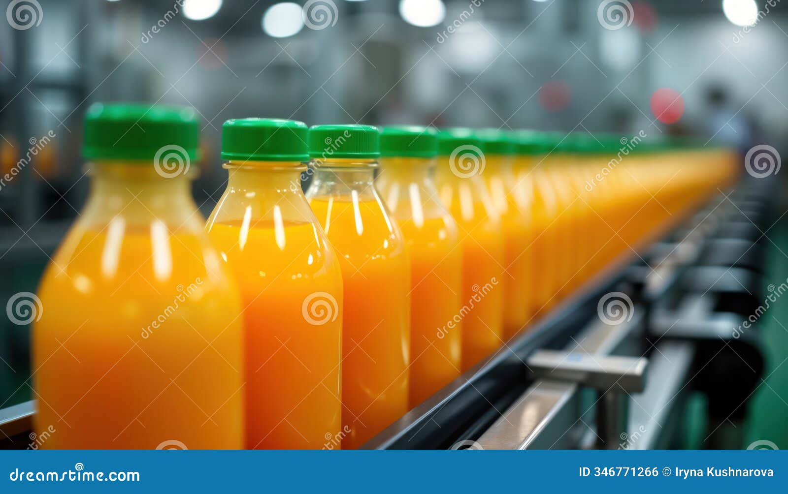orange juice bottles line up on conveyor belt in beverage production facility. automated bottling process in progress. modern