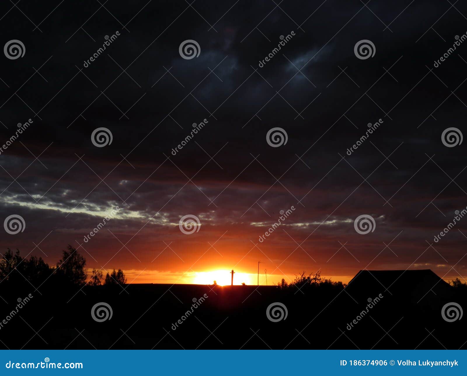The Orange Light of the Setting Sun Against a Dark Sky Stock Photo