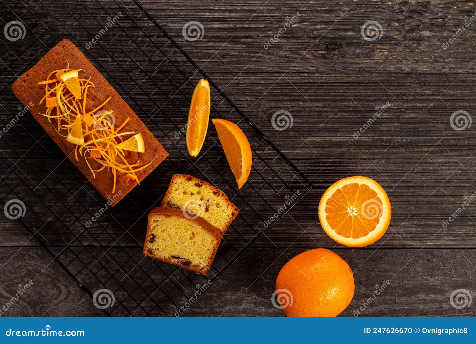 orange pound cake on a cooling rack alongside oranges on dark vintage wood background, flat lay. copy space