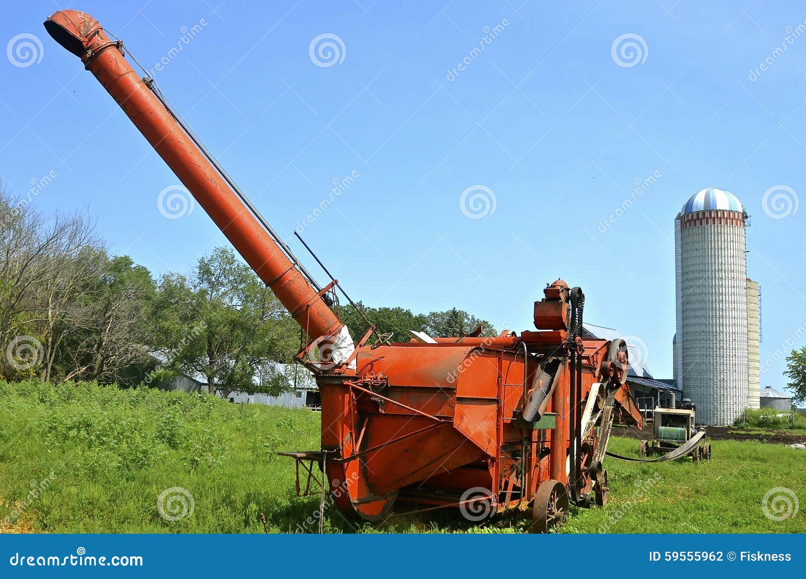 orange threshing machine on amish farm