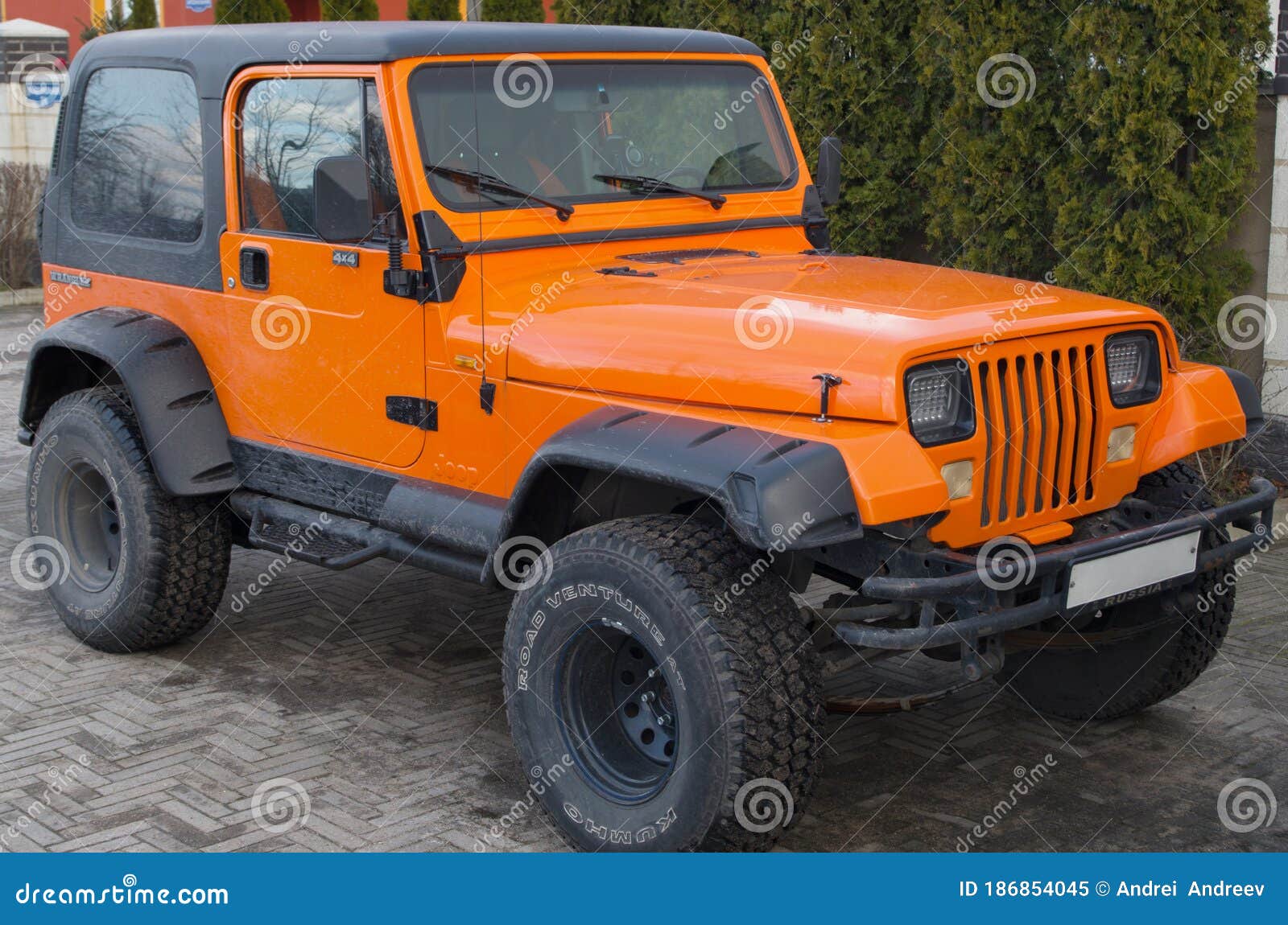 Orange Two Door Jeep Wrangler SUV with Gray Roof and Square Headlights  Standing on Gray Sidewalk Tiles in Front of House Editorial Image - Image  of auto, footboard: 186854045