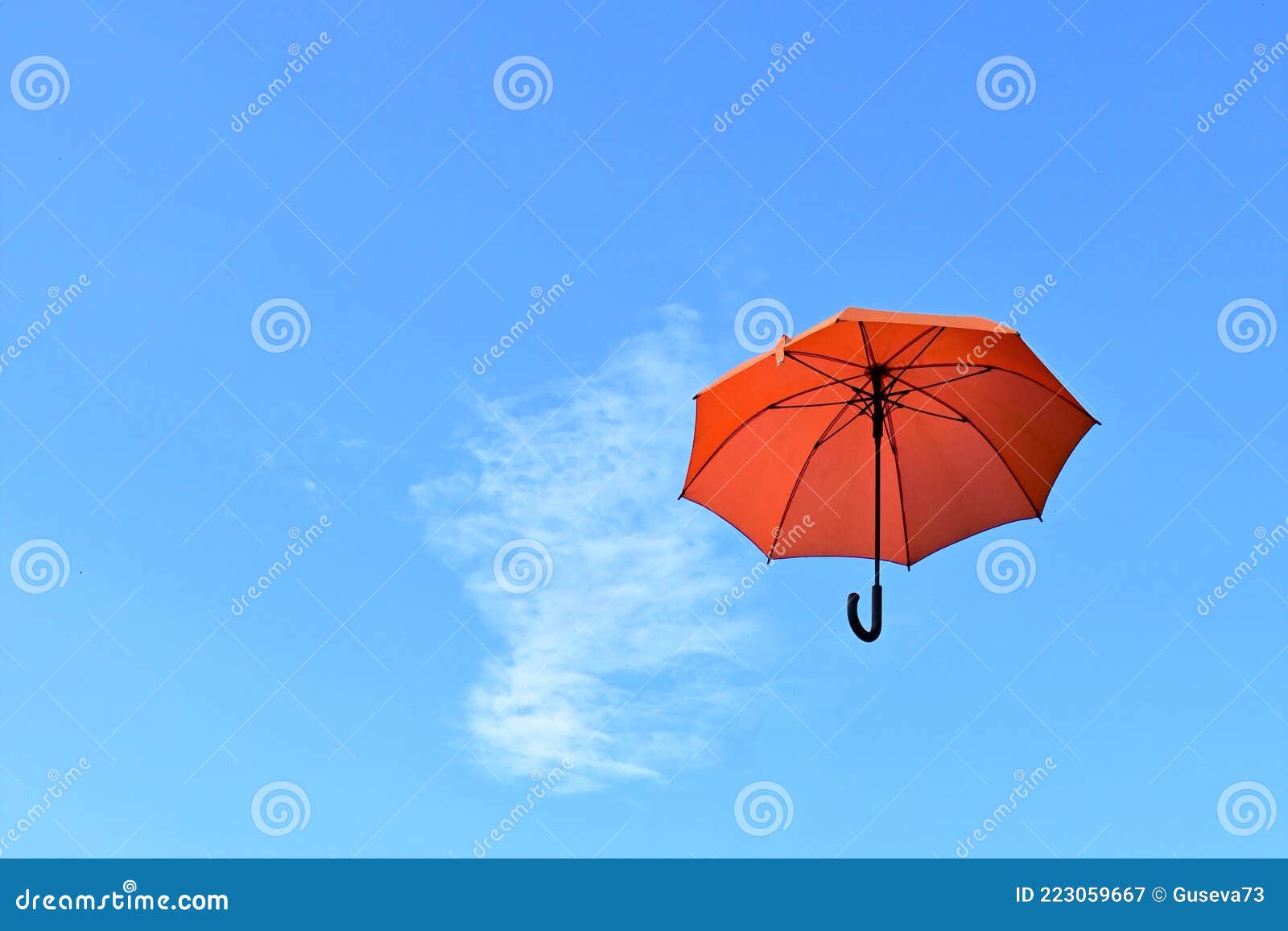 An Orange Umbrella Flying Away into the Blue Sky. Weather Changes