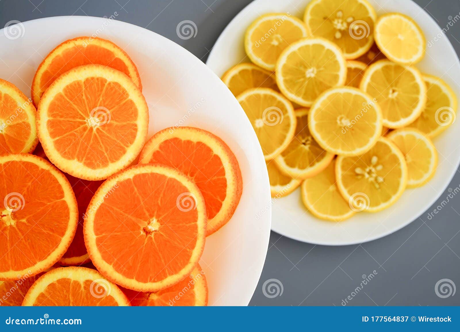 oranges and yellow lemons on a plate on a sunny day