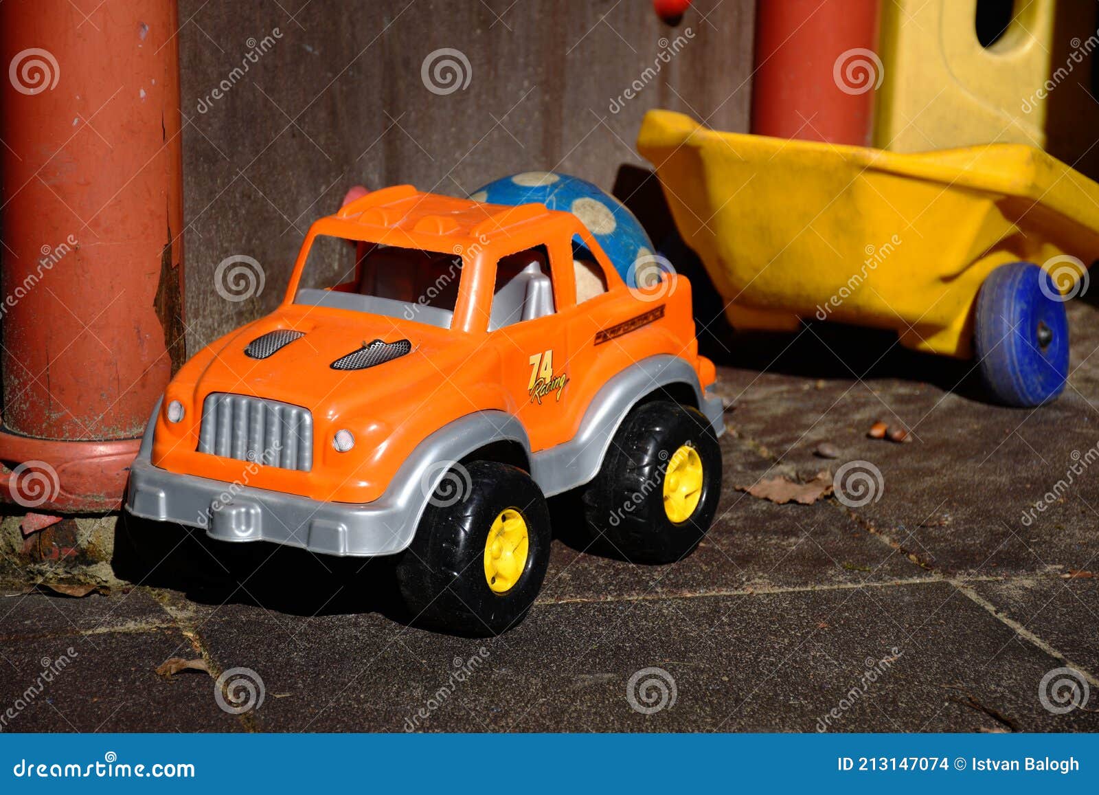 Voorman Hoogland Mooi Oranje Plastic Speelgoedauto Met Blauwe Rubberkogel in De Dop. Begrip  Buitenshuis Stock Foto - Image of blauw, veiligheid: 213147074
