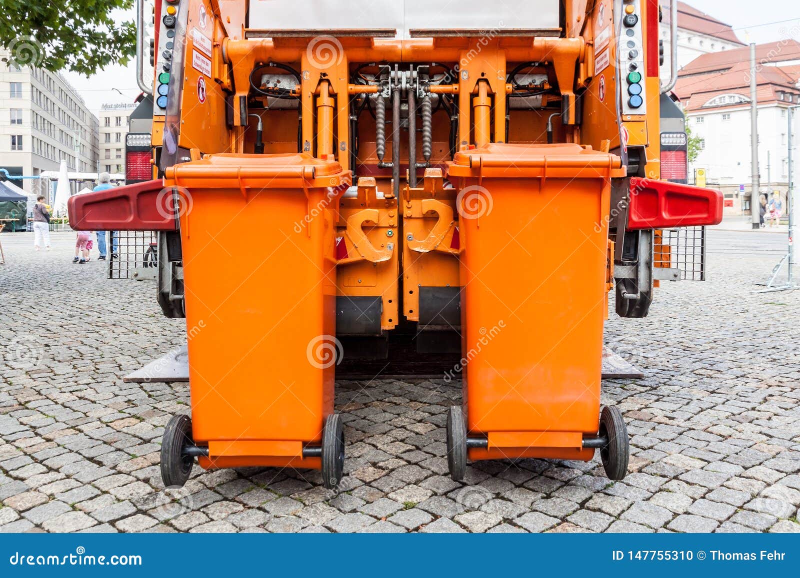 Oranje vuilnisauto. De oranje auto van de vuilniscollector met container