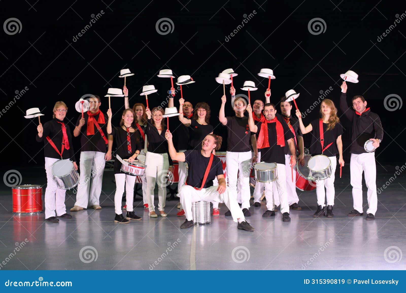 orchestra drummers in costumes with hats raised on