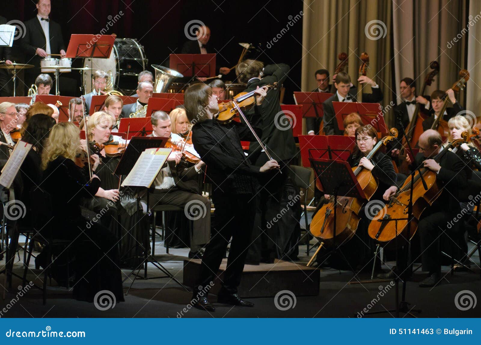 DNIPROPETROVSK, UCRAINA - 9 FEBBRAIO: Il violinista famoso Dmitry Tkachenko e l'orchestra sinfonica accademica eseguono al teatro russo di dramma dello stato il 9 febbraio 2015 in Dnipropetrovsk, Ucraina