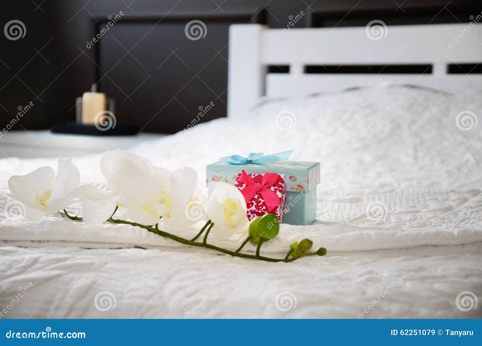 Orchid Flower and Gift Boxes on the Bed in the Bedroom. Horizontal