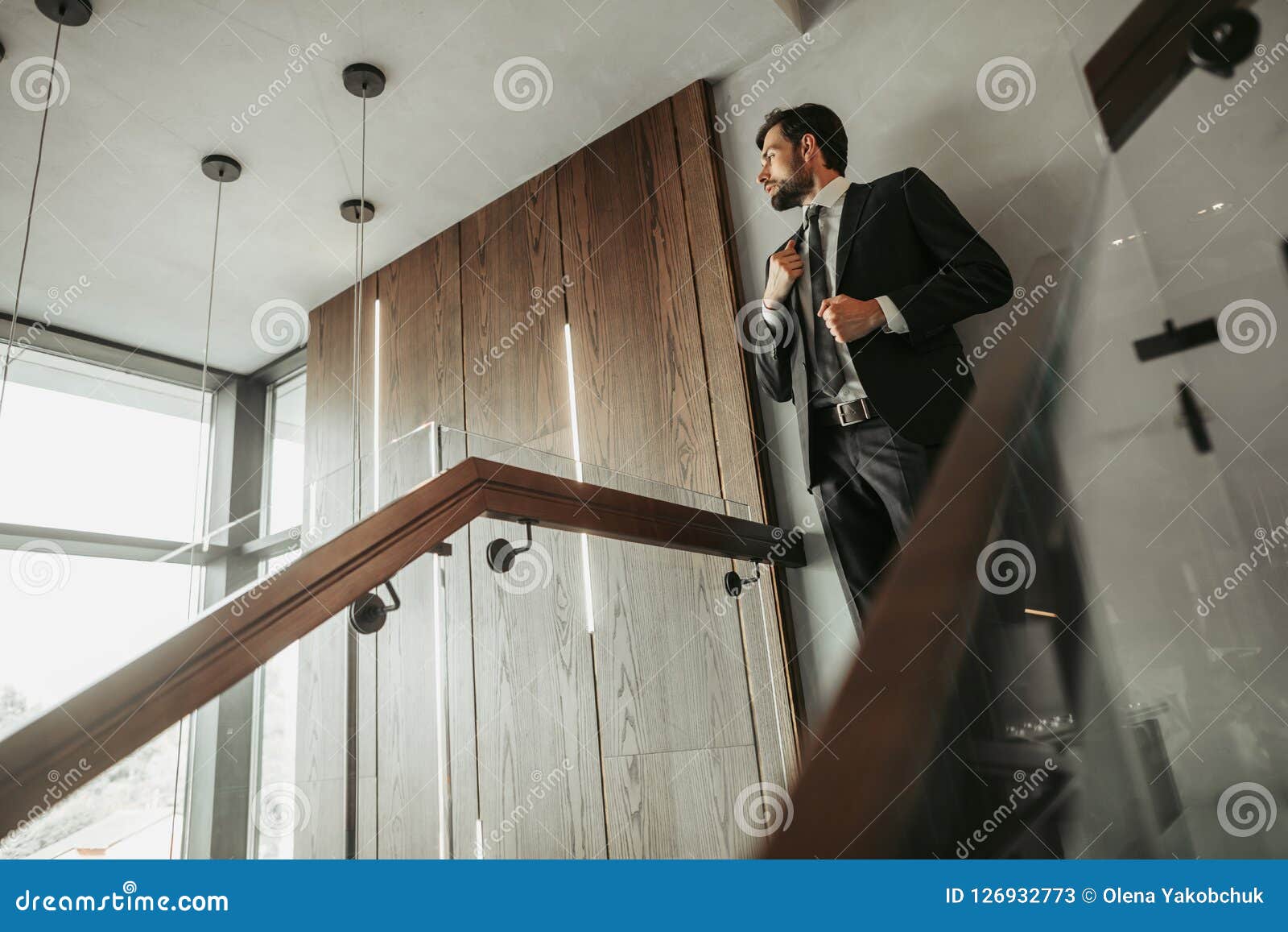 Orderly Man Locating On Modern Stairwell Landing Stock Image