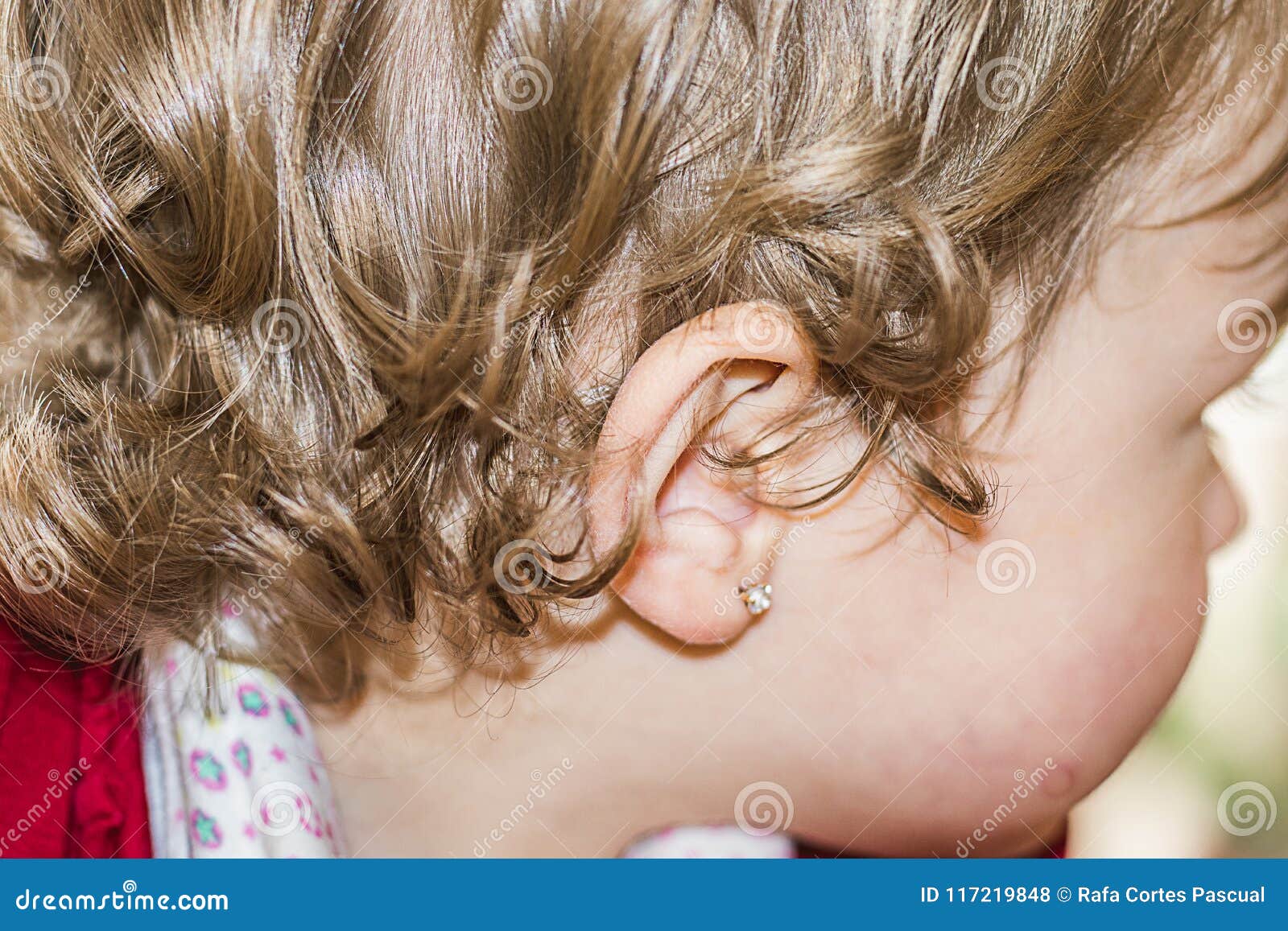 Oreille d'une petite fille avec une boucle d'oreille Plan rapproché d'une oreille du ` s de fille