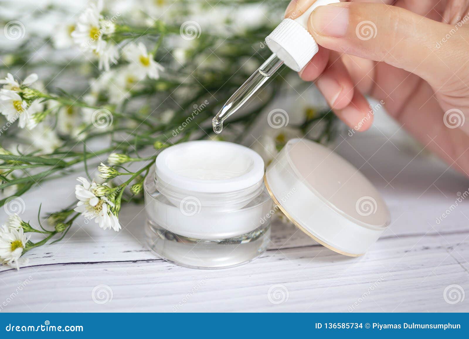 organic natural skincare concept. open blank cosmetic cream jar with white cream texture inside and women hand holding dropper