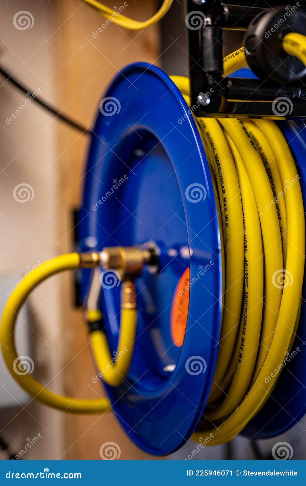 Auto-rewinding Air Hose Reel with Coiled Tubing Mounted on a Wall in a Shop  Stock Image - Image of flexible, compressor: 225946071