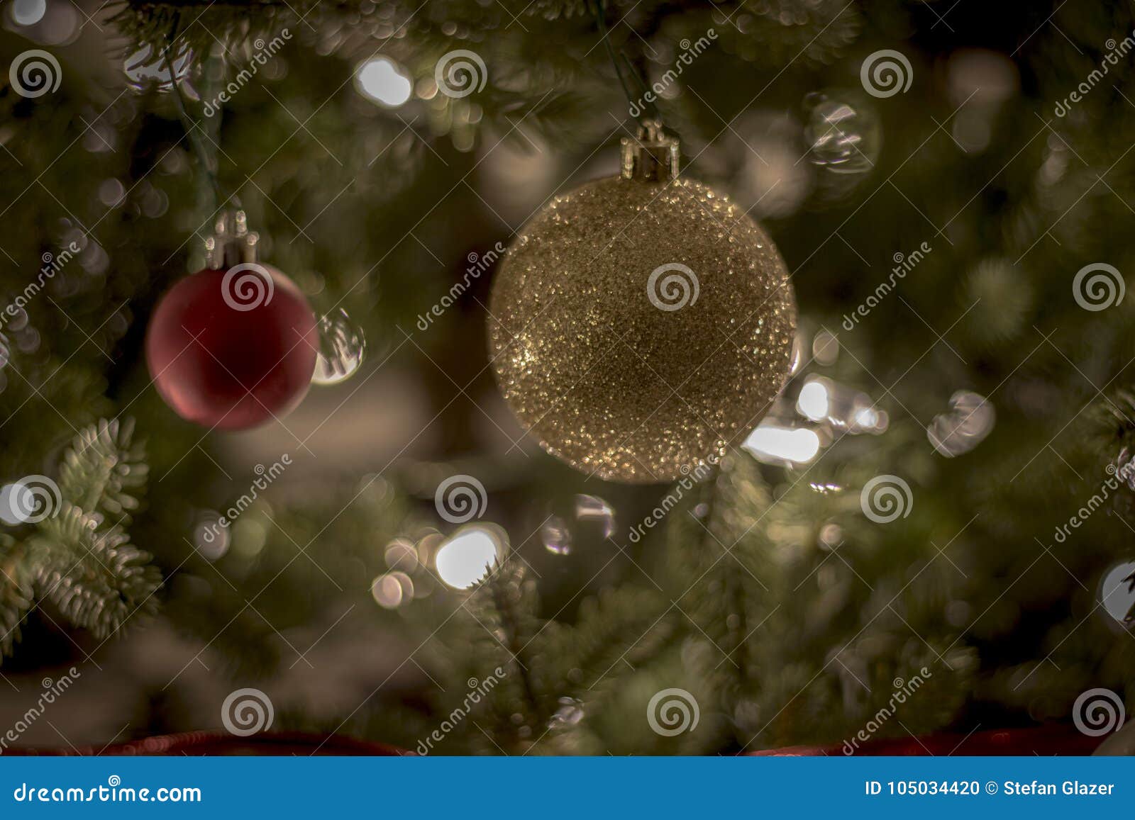 Ornamentos de la Navidad en las luces brillantes y felices de la noche con la cinta y el brillo. ¡Lanzamiento de última hora del árbol de navidad con los ornamentos y luces brillantes que brillan brillantemente con la noche!