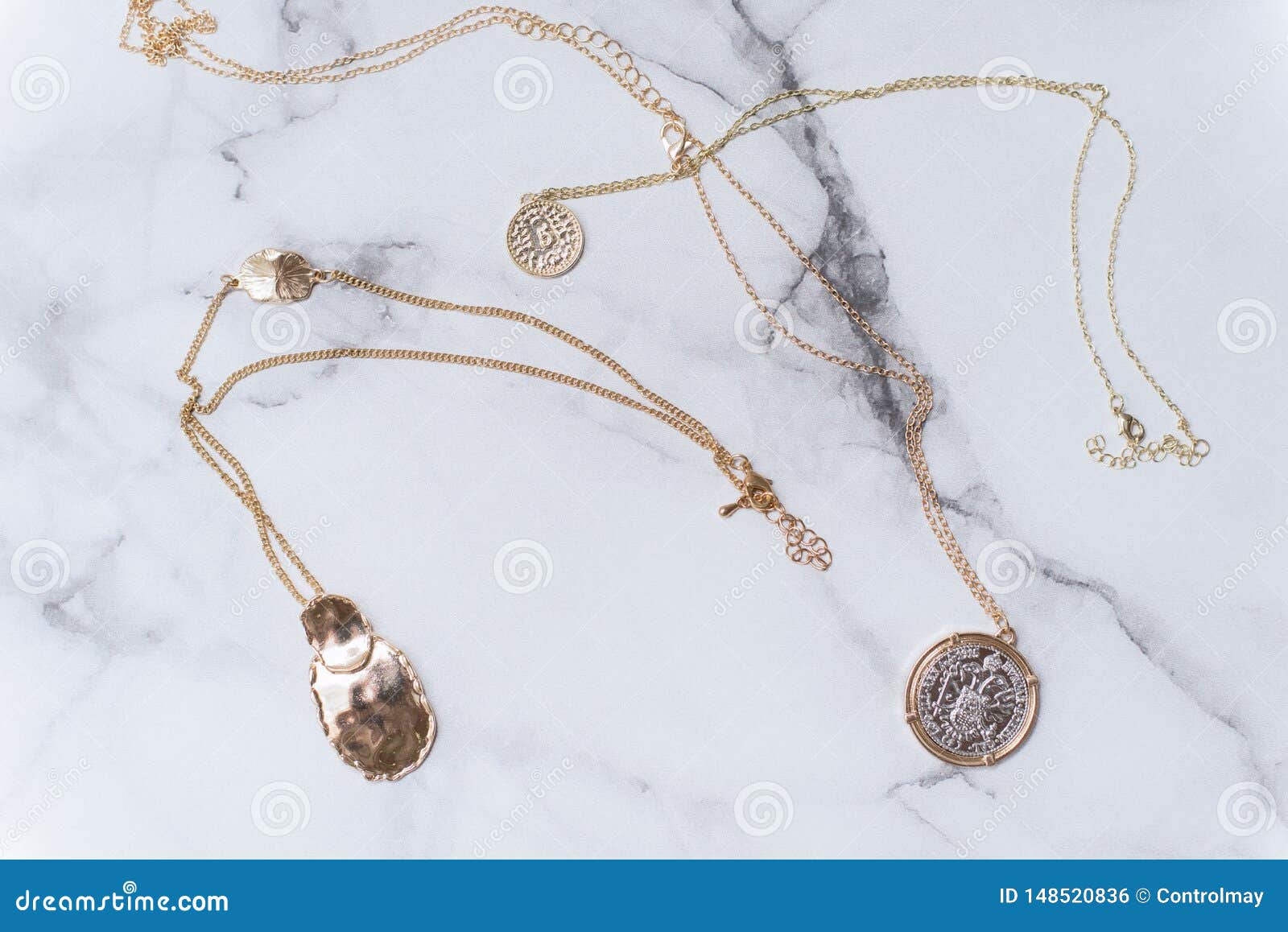 Ornamentos femeninos del oro en un fondo de mármol concepto de joyería hermosa