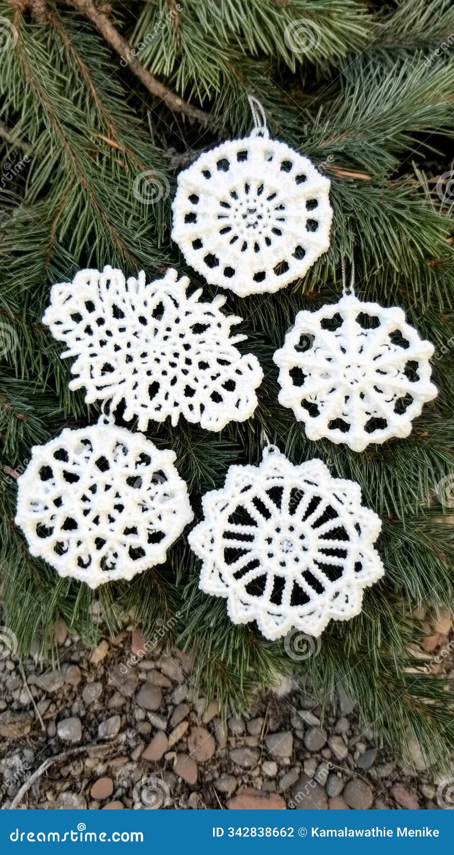 ornate snowflake ornaments on frosted pine branch