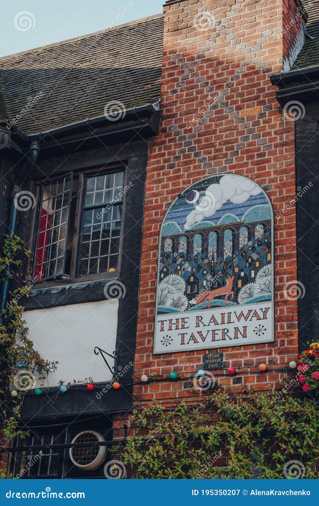 Ornate Tiles Sign by Tessa Hunkin on a Brick Wall of the Railway Tavern